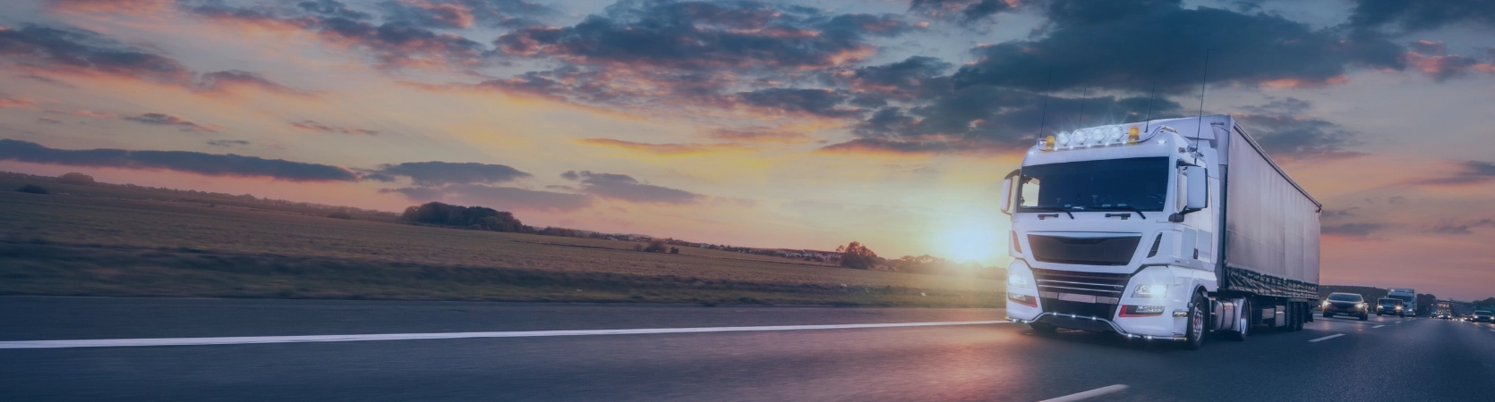 Poids lourd circulant sur autoroute au crépuscule, incarnant la puissance, la fiabilité et l’importance du transport routier longue distance.