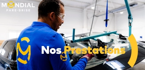 Technicien Mondial Pare-Brise procédant à la pose d’un pare-brise avec un système de levage assisté, alliant sécurité, précision et technologie en atelier.